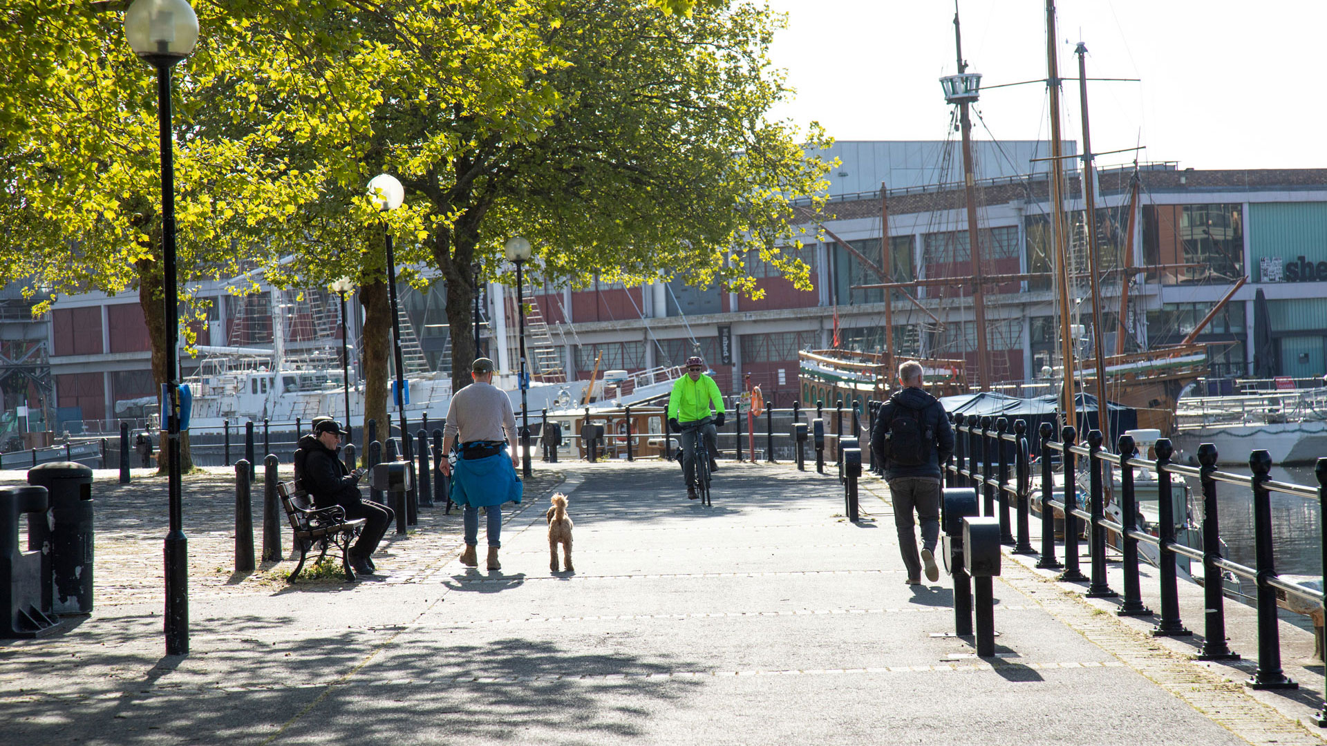 People walking and cycling alongside Bristol floating harbour