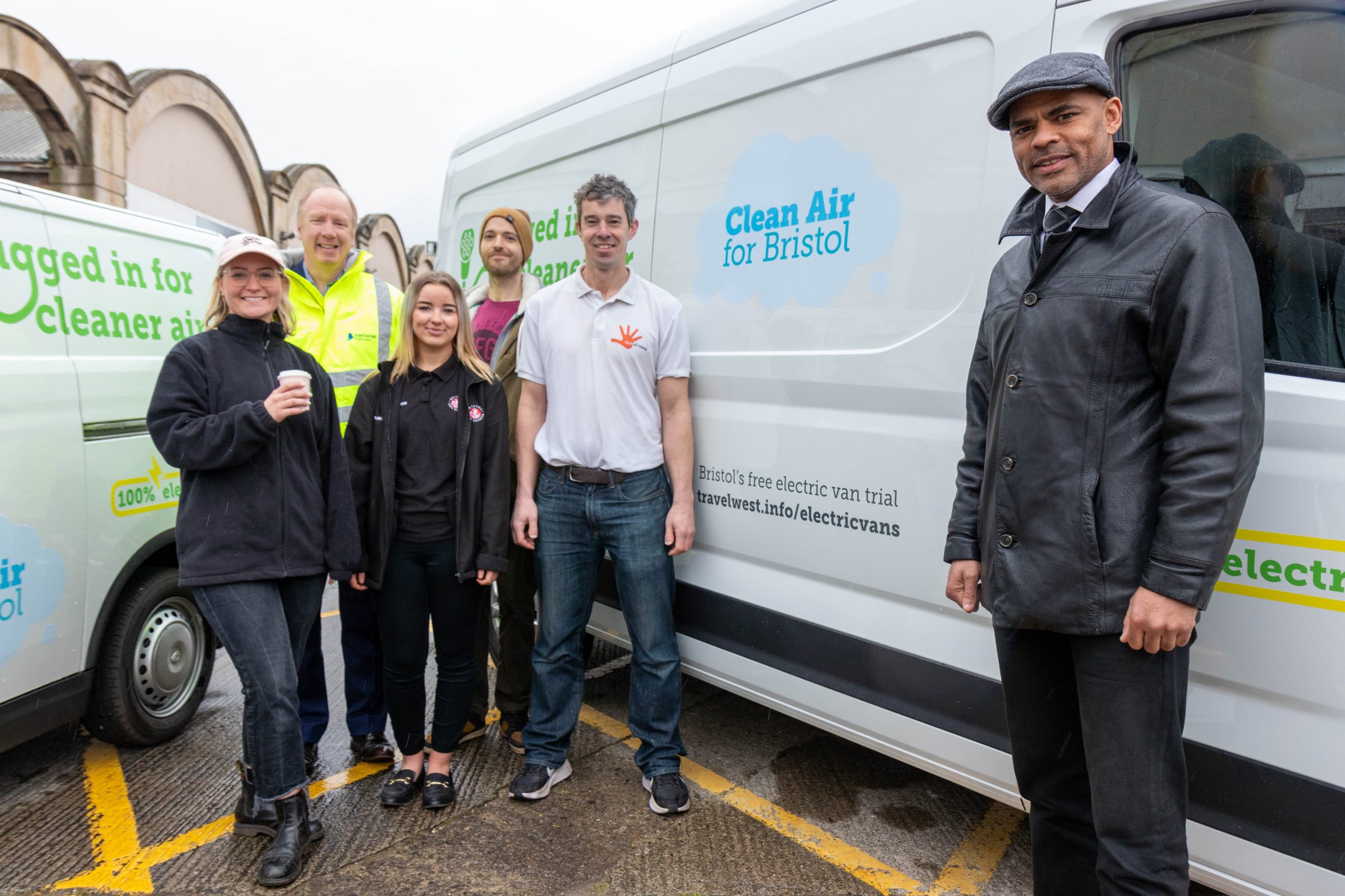 People stood next to electric vans